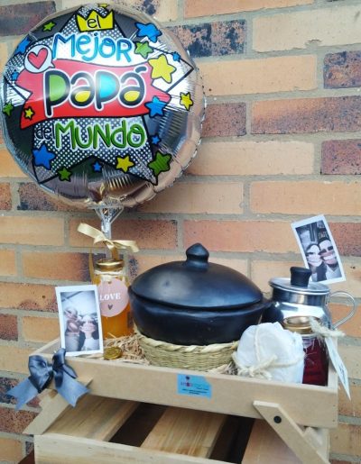 DESAYUNO SORPRESA MI GRAN HÉROE:· Ollita de barro en canastos de mimbre,  en su interior deliciosos caldo de carne con papa o tamal · Chocolatada en agua o leche deslactosada segun eleccion, hirviendo, en olleta chocolatera miniatura con tapa · Jugo de naranja · 2 Panes · Gelatina casera-Set de cubiertos en madera · Linda tarjeta  caja en madera set de 2 fotos