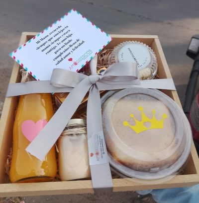 DELEITE: Contiene  -Sándwich de jamón y queso  -Chocolates   -Jugo de naranja  -Frasquito con yogurt y cereal  -Fruta picada  -Set de cubiertos en madera  -Bandeja en madera  -Tarjeta personalizada