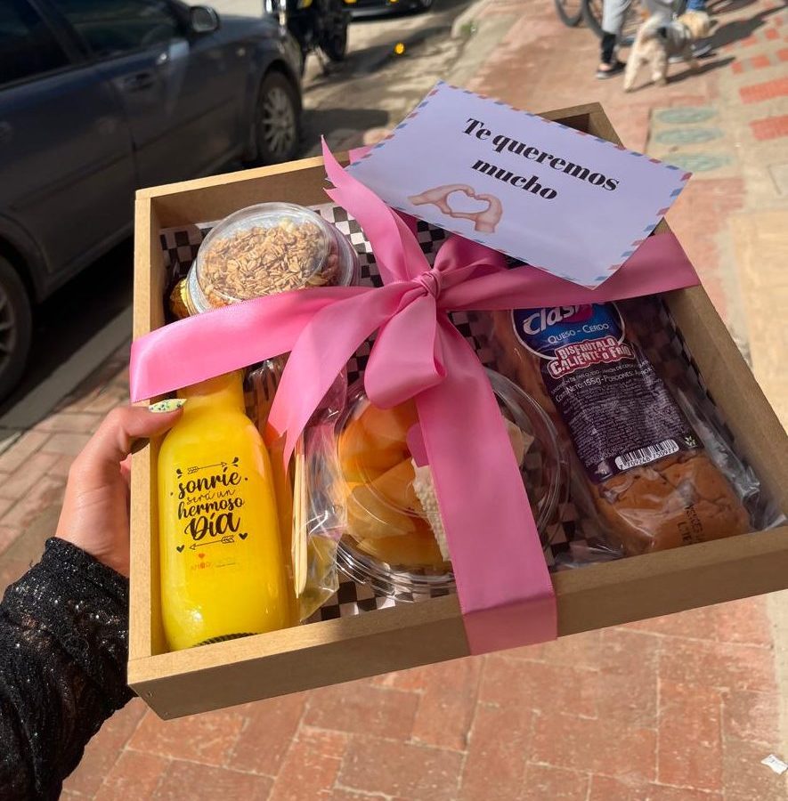 DELEITE: Contiene  -Sándwich de jamón y queso  -Chocolates   -Jugo de naranja  -Frasquito con yogurt y cereal  -Fruta picada  -Set de cubiertos en madera  -Bandeja en madera  -Tarjeta personalizada