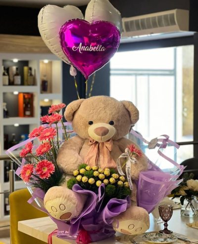 HERMOSO OSO EN PARAISO (Hermoso peluche de 70 cm altura en cama de paraiso floral, con globos en hlio personalizados y chocolates ferrero x 24 unidades)