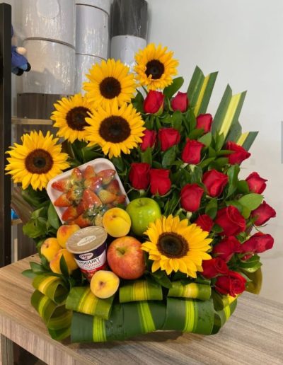 ESTACION DE PRIMAVERA: Elaborado con 20 hermosas rosas en follage, en base de madera, contiene girasoles, manzanas,  duraznos, fresas, granadilla, yogourt